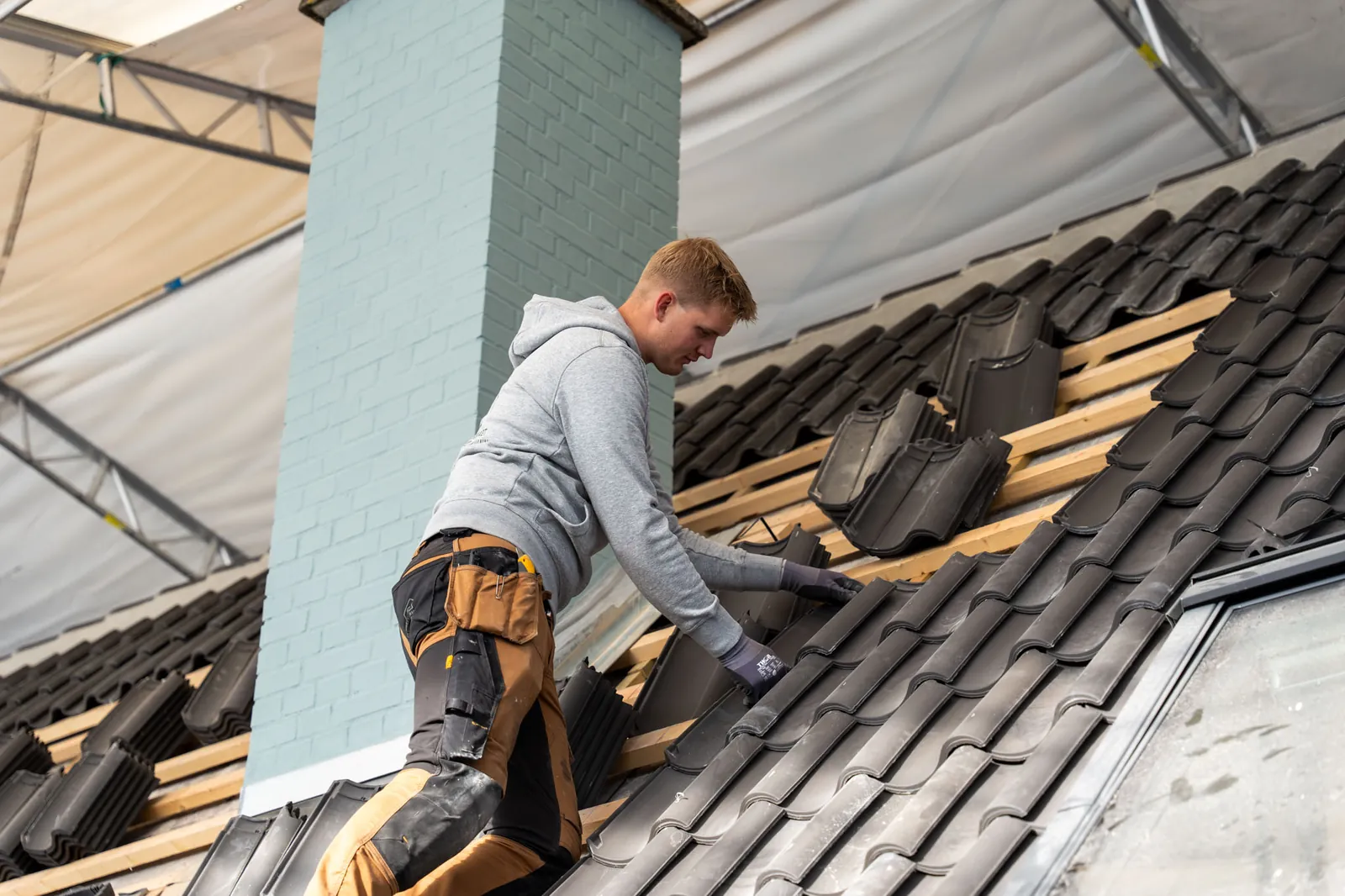 Tømrer fra Tømrerfirmaet Holmstrøm-Hollmann arbejder ved skorstenen på et hus under renovering