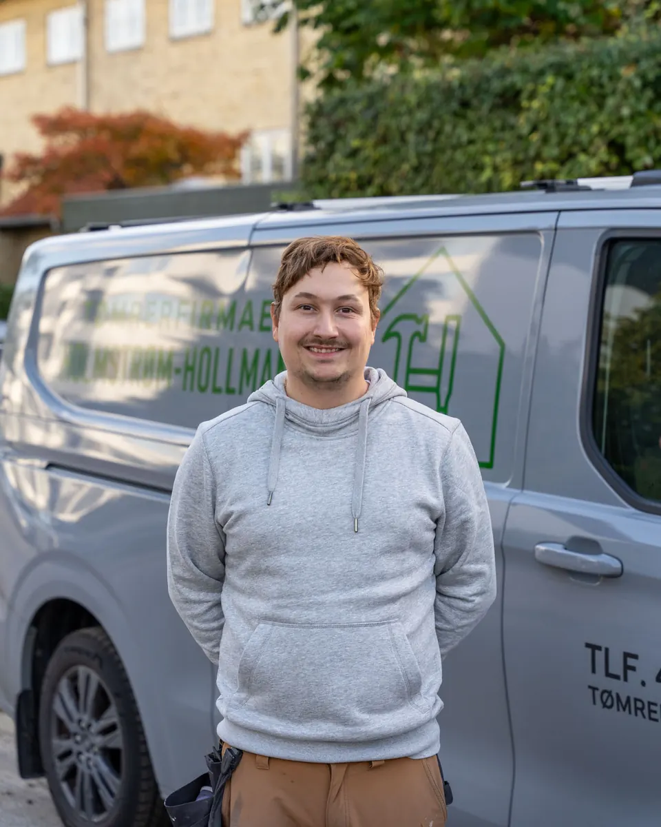 Kevin Lindahl-Bjørnestad, tømrermester hos Tømrerfirmaet Holmstrøm-Hollmann, foran firmabilen